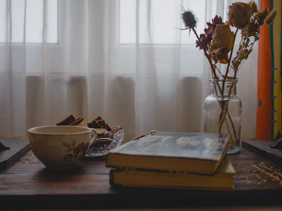 A cozy scene featuring a stack of beautifully illustrated storybooks with a warm cup of tea.