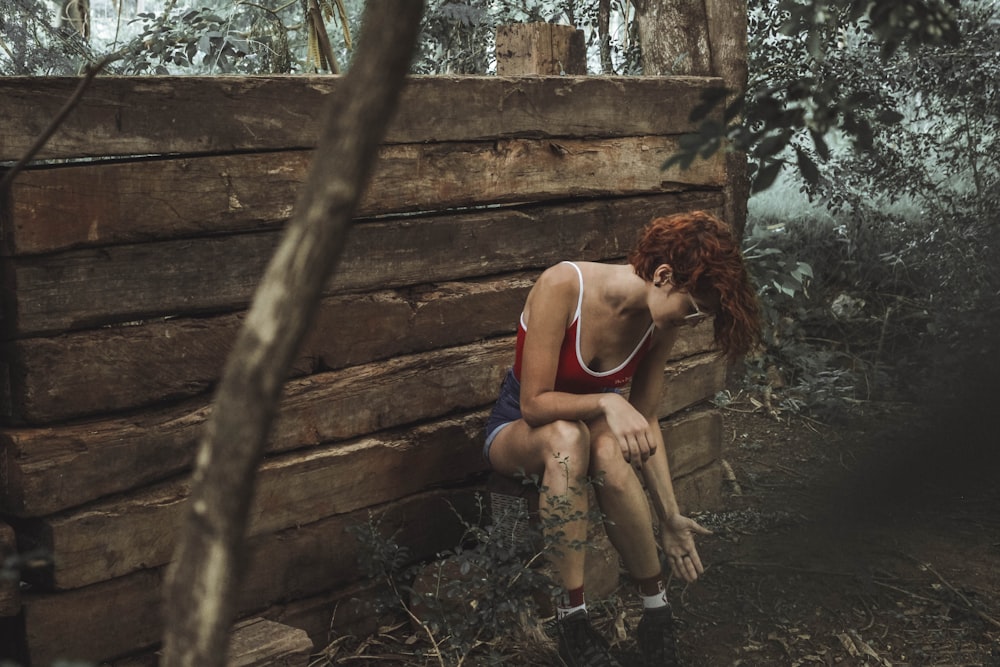 woman in purple tank top sitting on brown wooden stairs