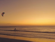 person walking on beach during sunset