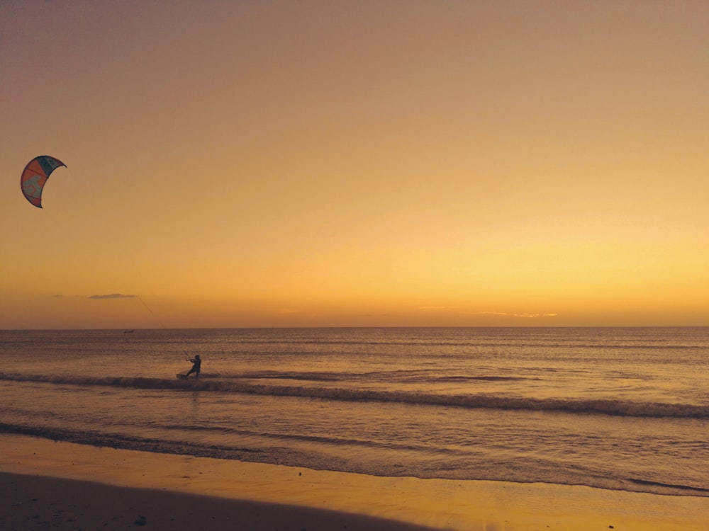 person walking on beach during sunset