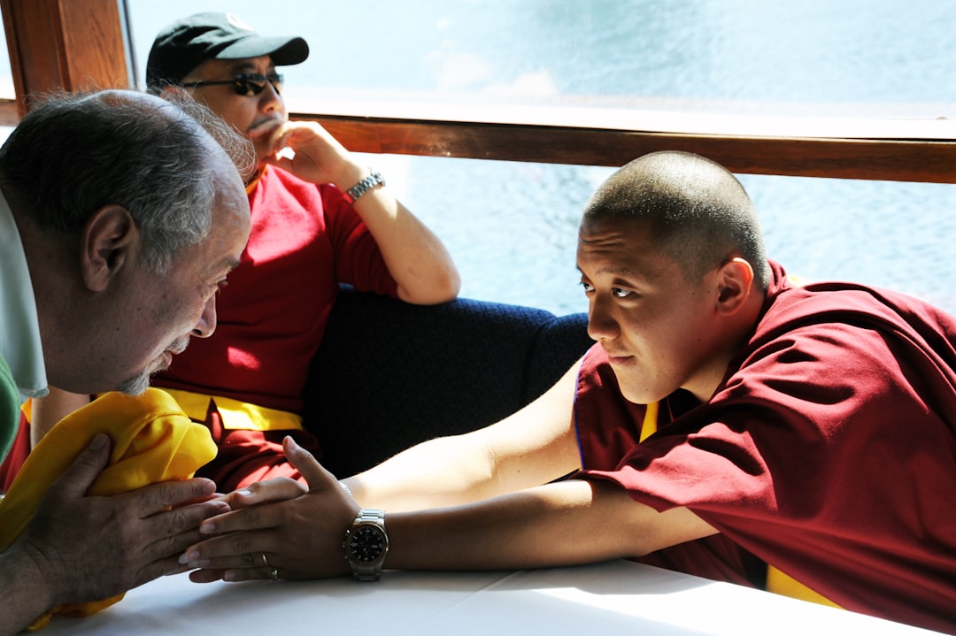 Dilgo Khyentse Yangsi Rinpoche reaches out to a Buddhist student, a man holding a deep yellow kata, Rabjam Rinpoche, Abbot of Shechen Monastery, onboard ship, Life Release, semchen tsetar tangpa, Lotus Speech Canada. This is a blessed image. Please, If printed do not place on the floor, do not step over or on, after use please burn.
