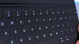 A close-up of a tablet keyboard attachment with a user typing comfortably.
