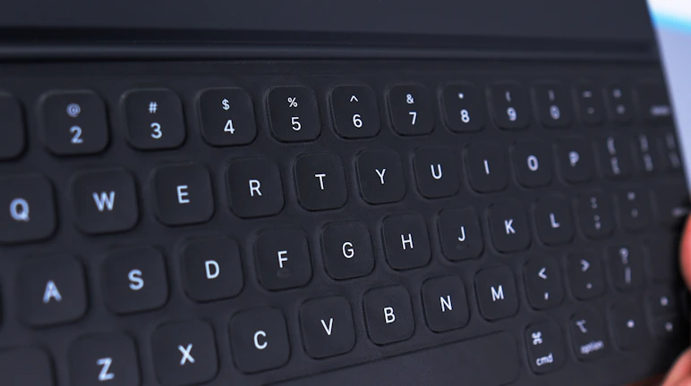 A close-up of a tablet keyboard attachment with a user typing comfortably.