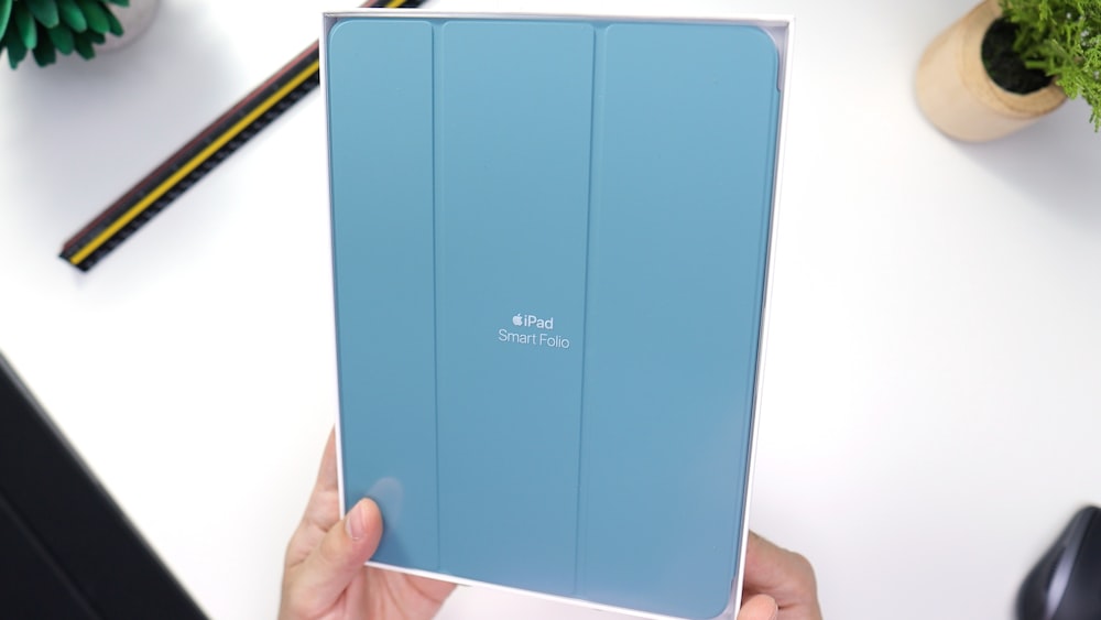 person holding blue folder with white background