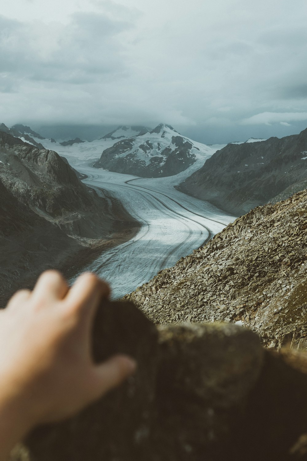 persons hand on brown rocky mountain during daytime