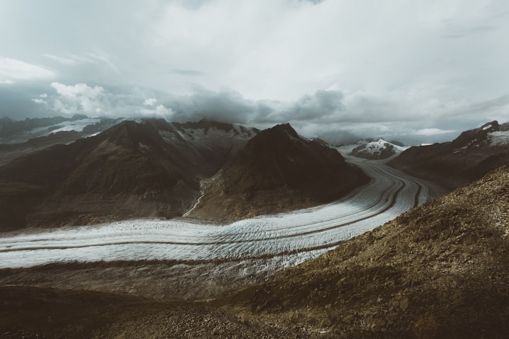 brown and white mountains under white clouds during daytime