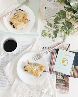 Close-up of a stamped passport alongside a steaming bowl of international food from Fiji Craft.