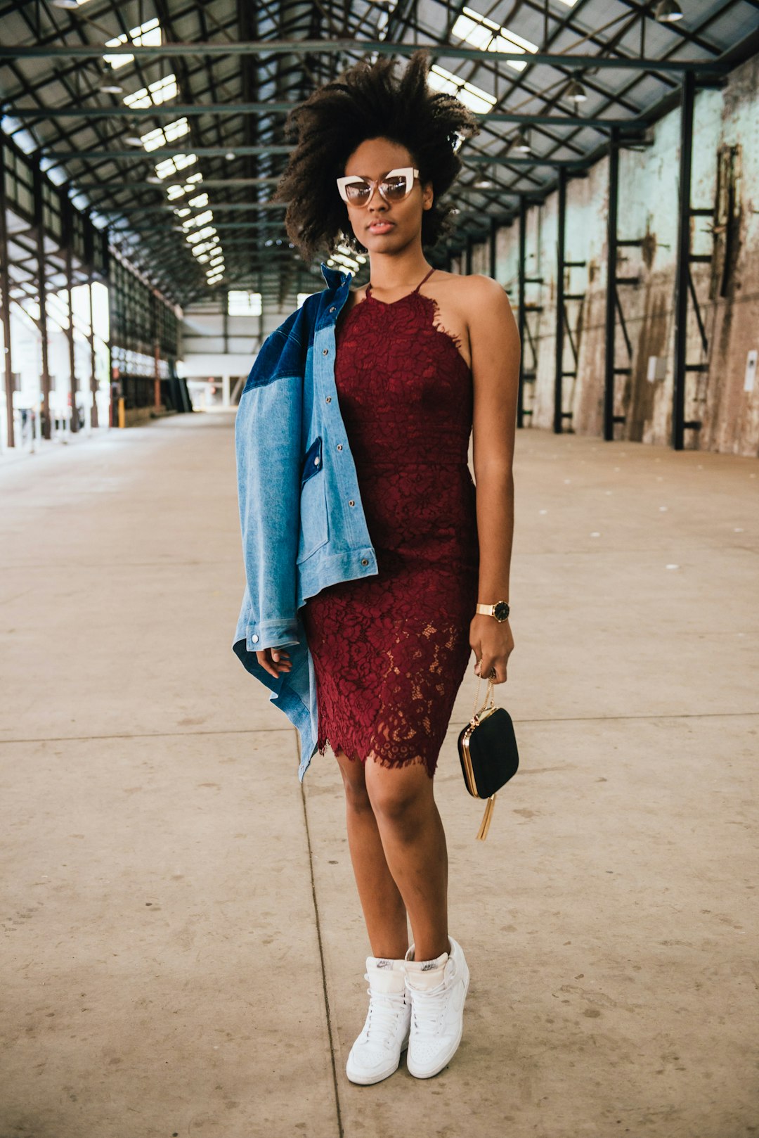 woman in blue sleeveless dress standing on gray concrete pathway during daytime