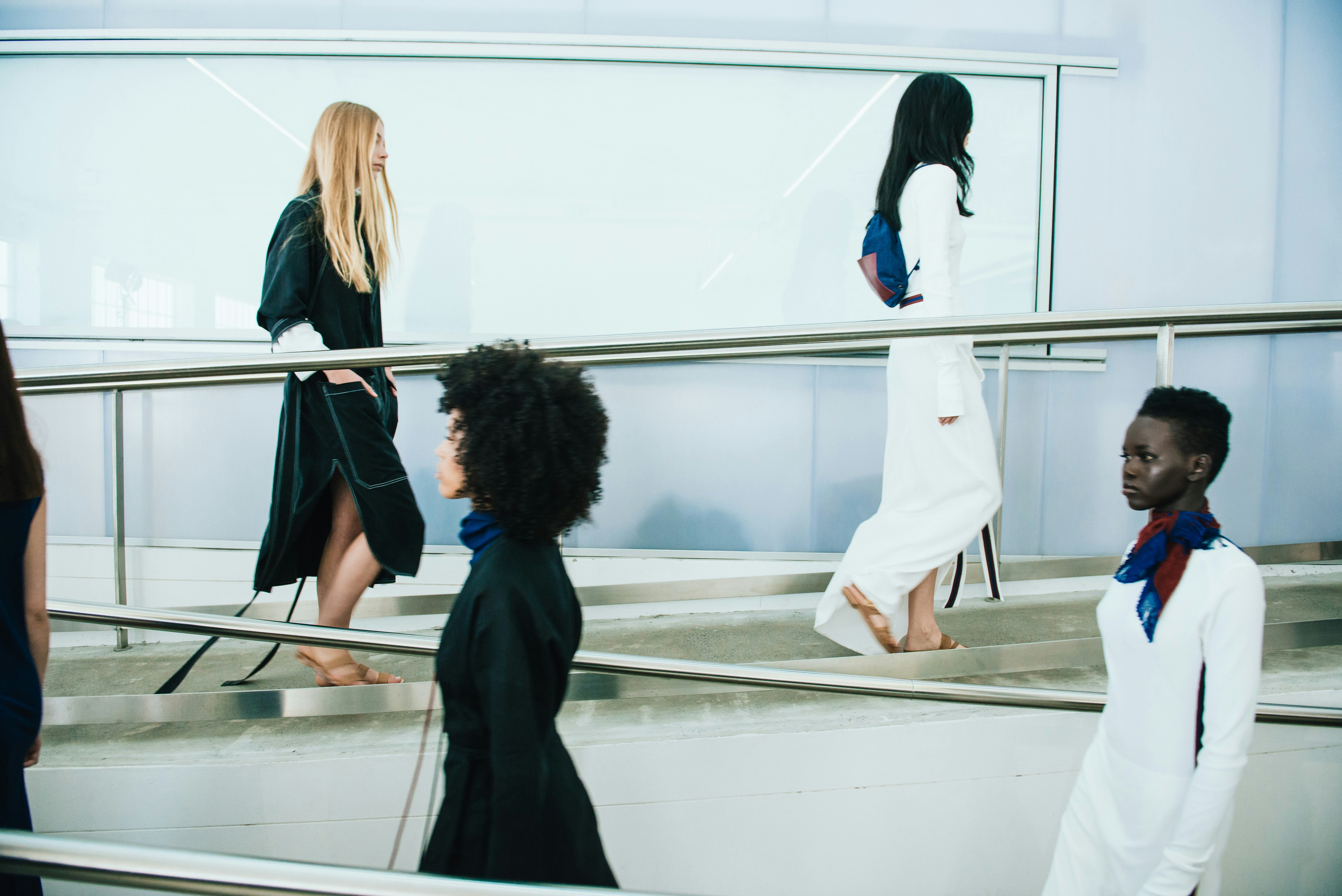 2 women in black coat standing in front of glass wall