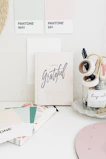 Minimalist workspace featuring colorful pens, stamps, and paper supplies neatly organized