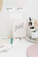 Minimalist workspace featuring colorful pens, stamps, and paper supplies neatly organized