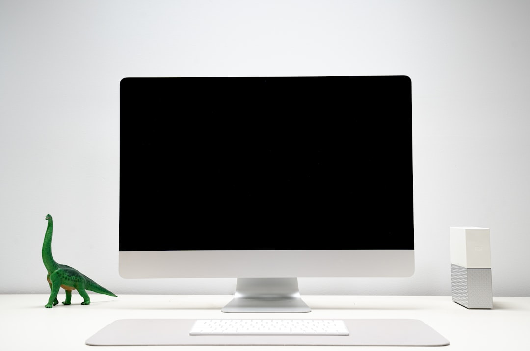 Apple iMac Desktop Setup with Dinosaur on desk