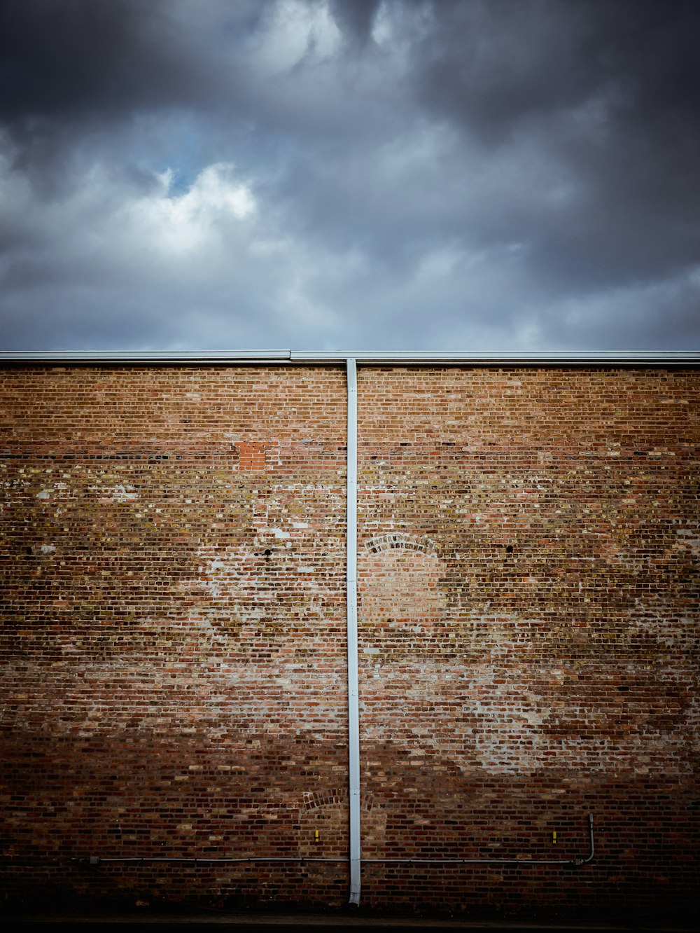 brown brick wall under cloudy sky during daytime