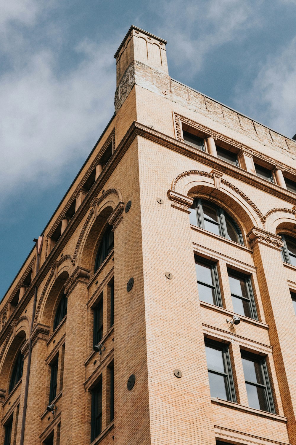 brown concrete building under white clouds during daytime