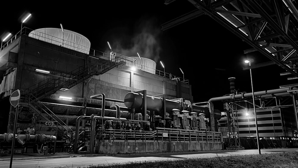 grayscale photo of factory with smoke