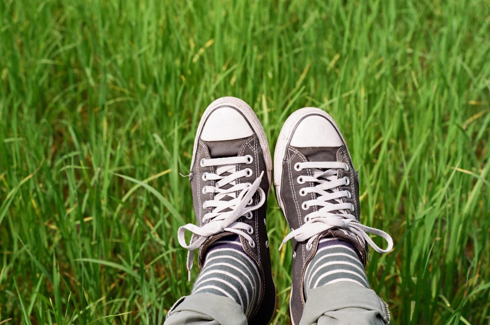 person wearing black and white converse all star high top sneakers