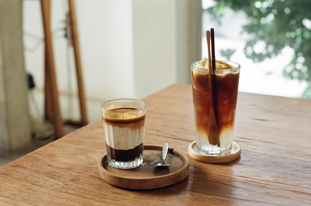 clear drinking glass with brown liquid on brown wooden table