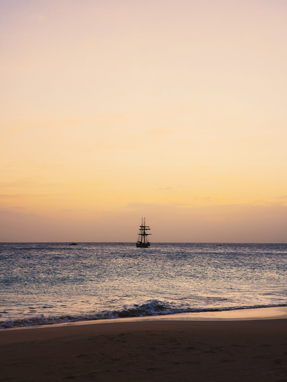 silhouette of ship on sea during sunset