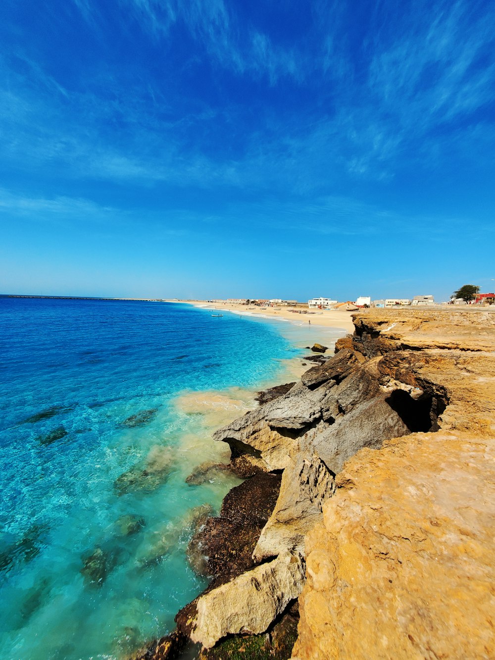 brown rocky shore under blue sky during daytime