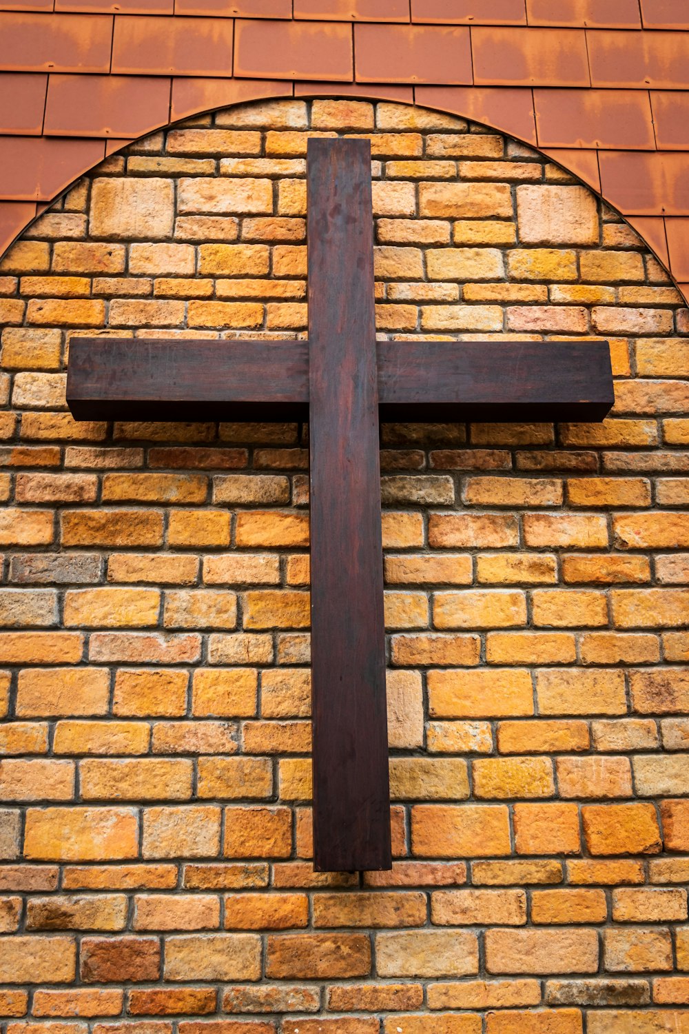 black cross on brown brick wall