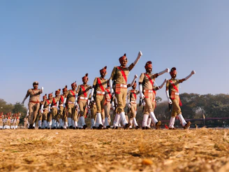 Young trainees in uniform practicing physical drills on a sunny outdoor field.