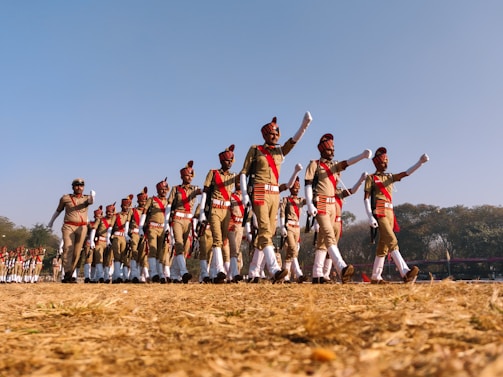Students marching in formation on a track field, showing teamwork and discipline.