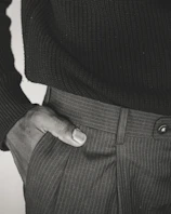 Close-up of a woman’s hand slipping into a sleek pocket on a flowing summer dress.