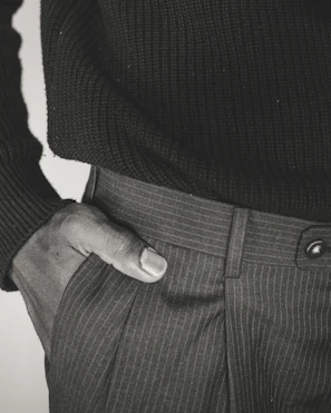 Close-up of a woman’s hand slipping into a sleek pocket on a flowing summer dress.