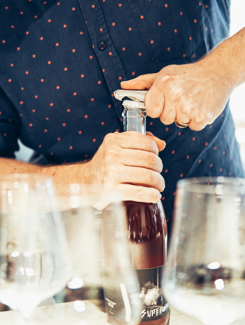 person pouring a clear drinking glass