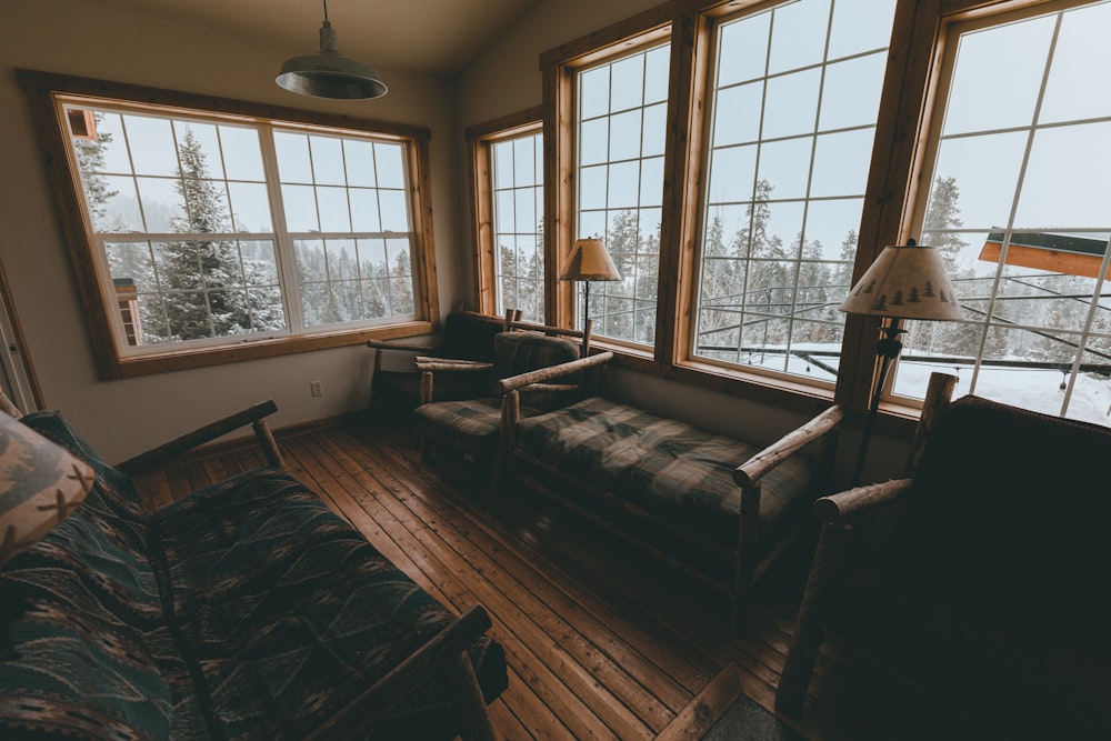 a living room filled with furniture and large windows