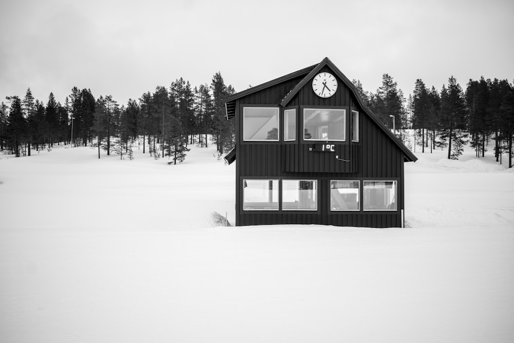 black wooden house in the middle of snow covered ground