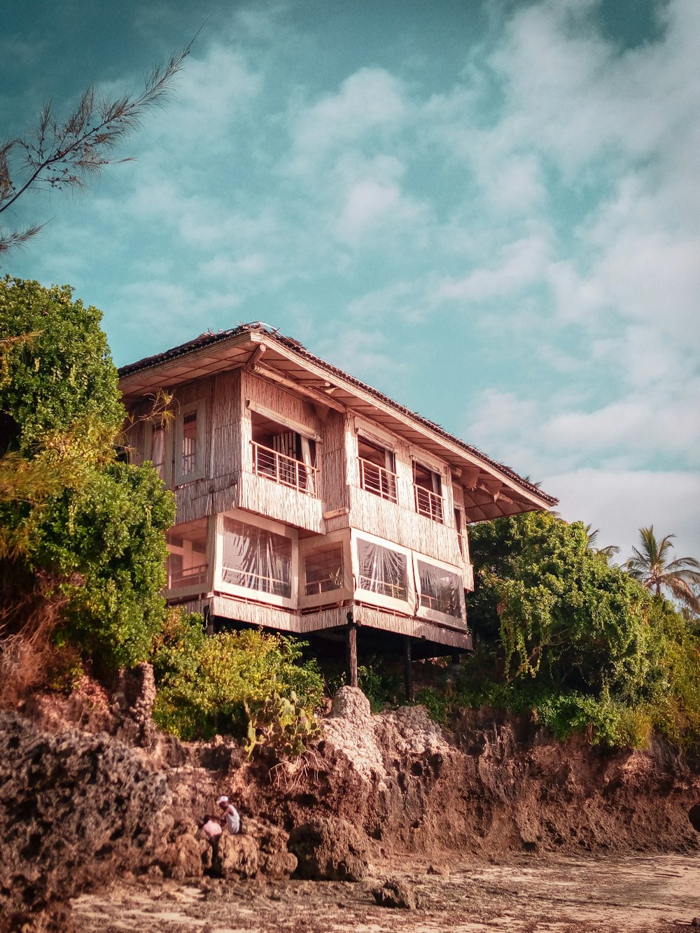 white and brown wooden house surrounded by green trees under blue sky during daytime