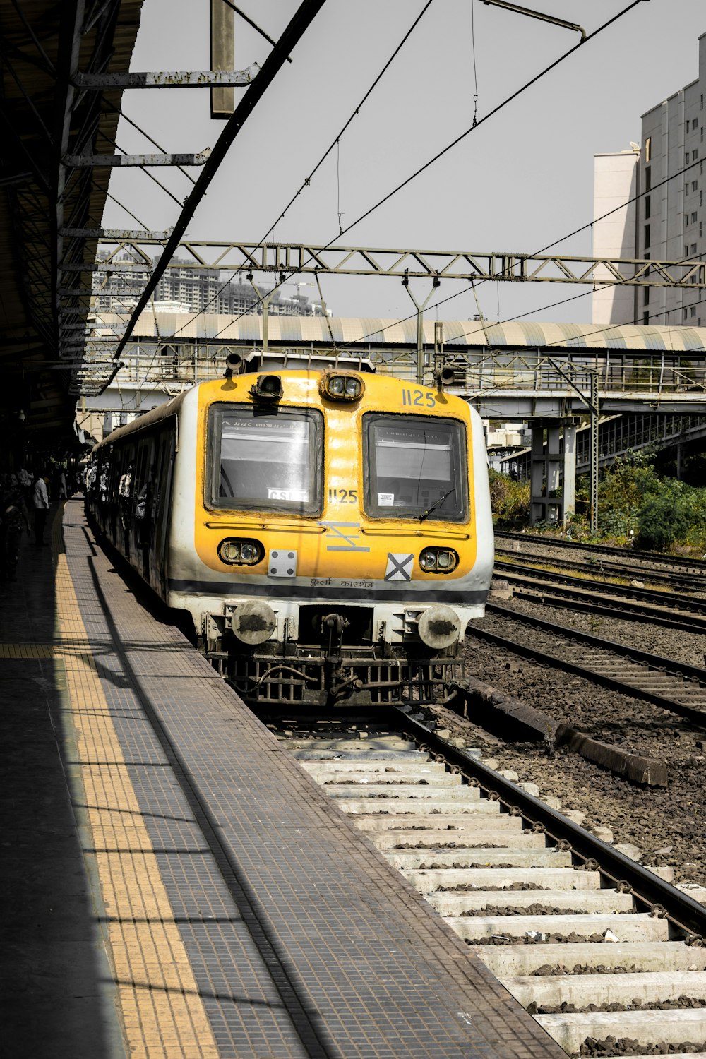 yellow and black train on rail tracks during daytime