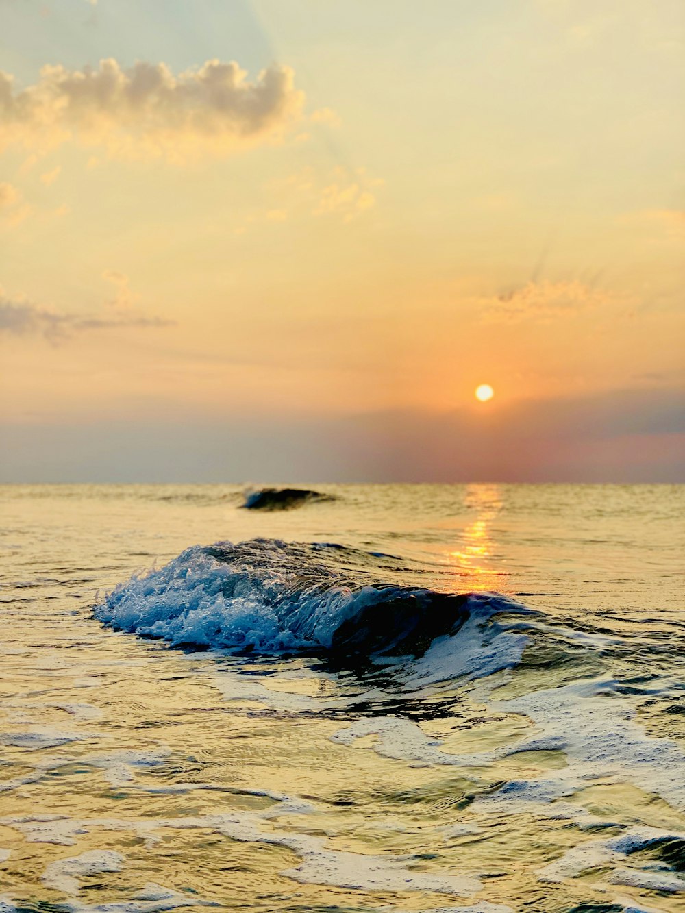 sea waves crashing on shore during sunset