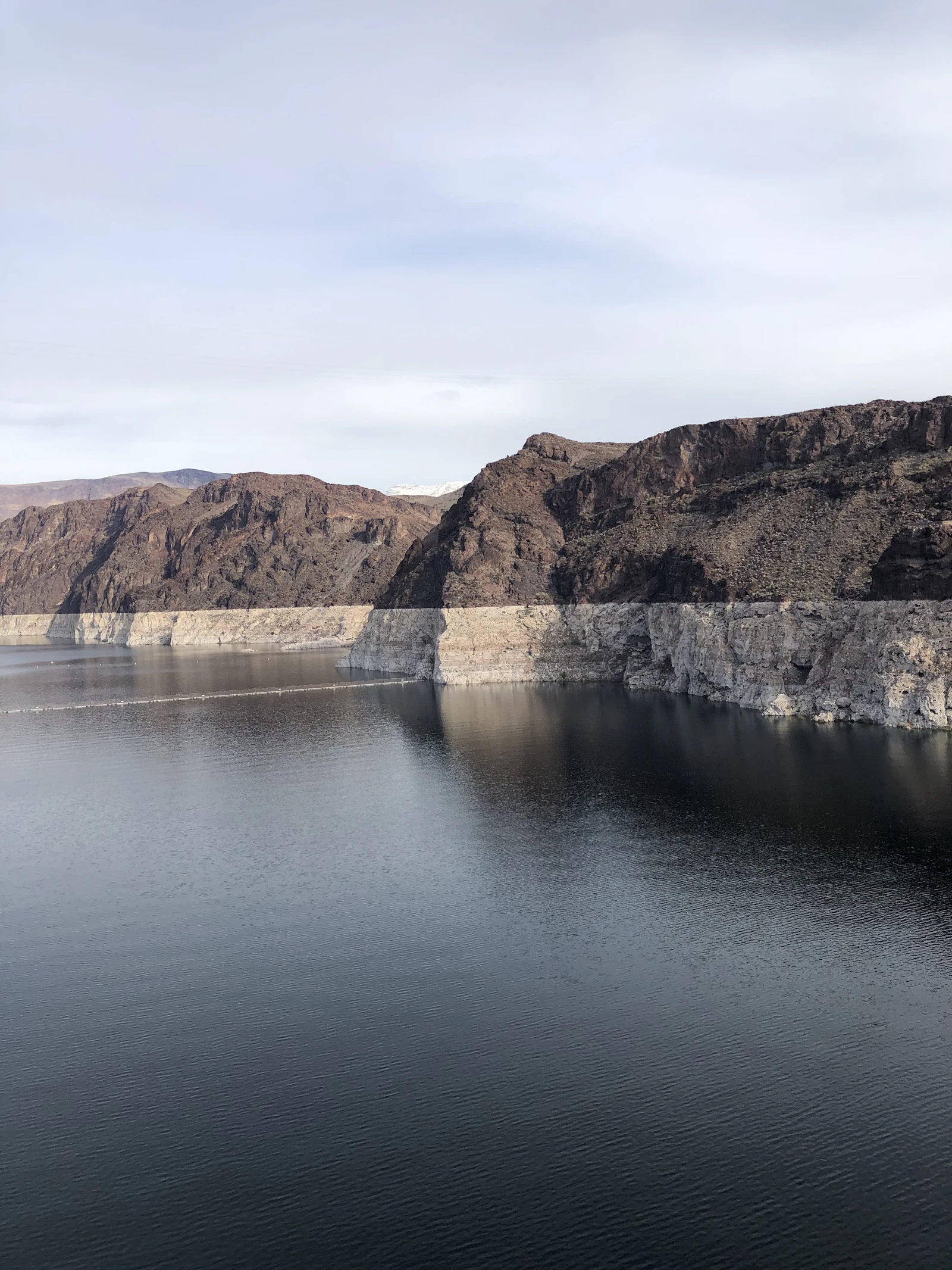 A reservoir between bare desert mountains.