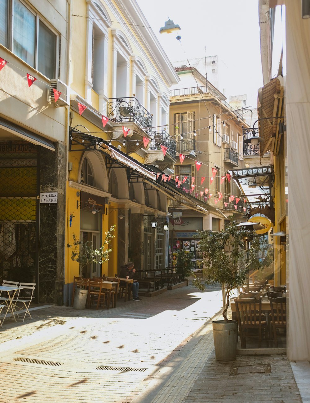 brown wooden table and chairs near brown concrete building during daytime