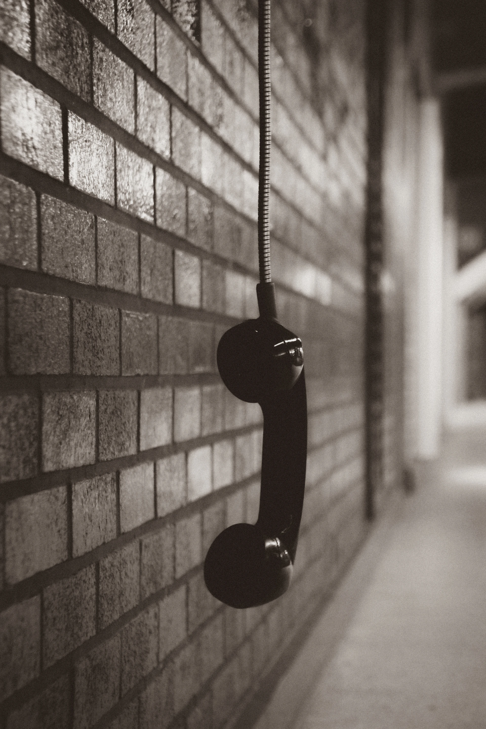 black telephone on brown brick wall