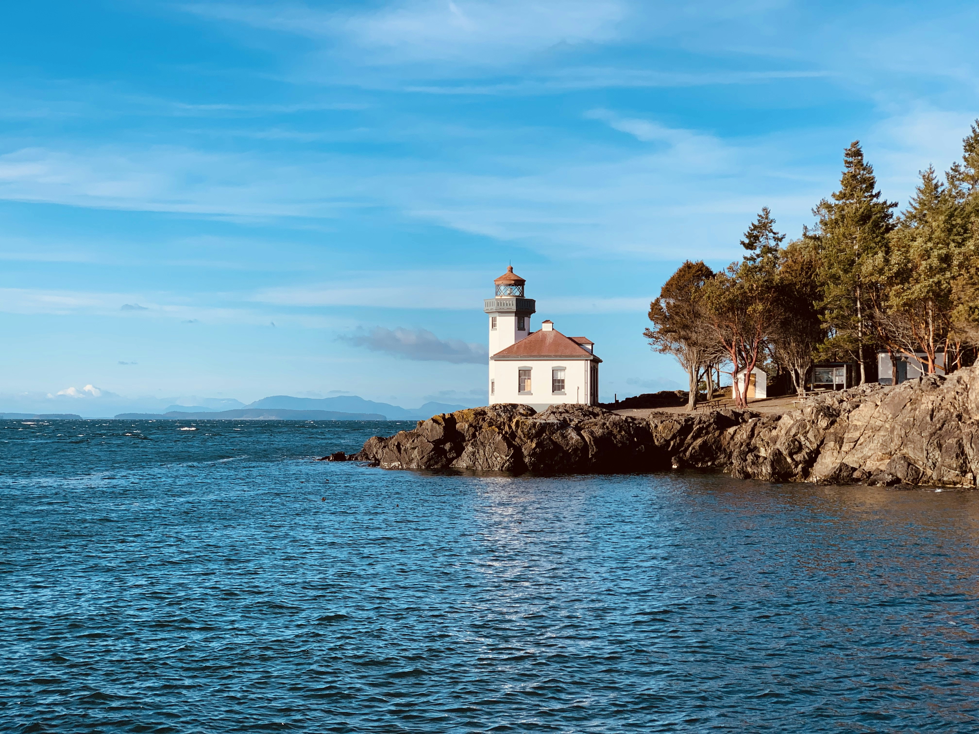white and brown concrete building near body of water during daytime