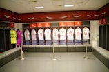 Display of various football jerseys arranged neatly with a promo code card.