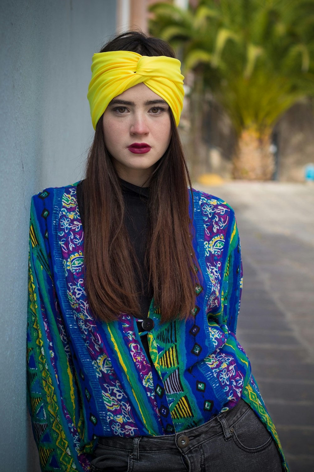 파란색과 노란색 꽃무늬 긴팔 셔츠와 노란색 니트 모자를 쓴 여자