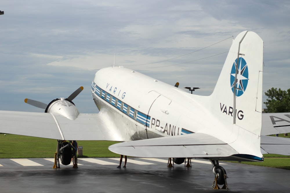 people walking on the street near white airplane under white clouds during daytime