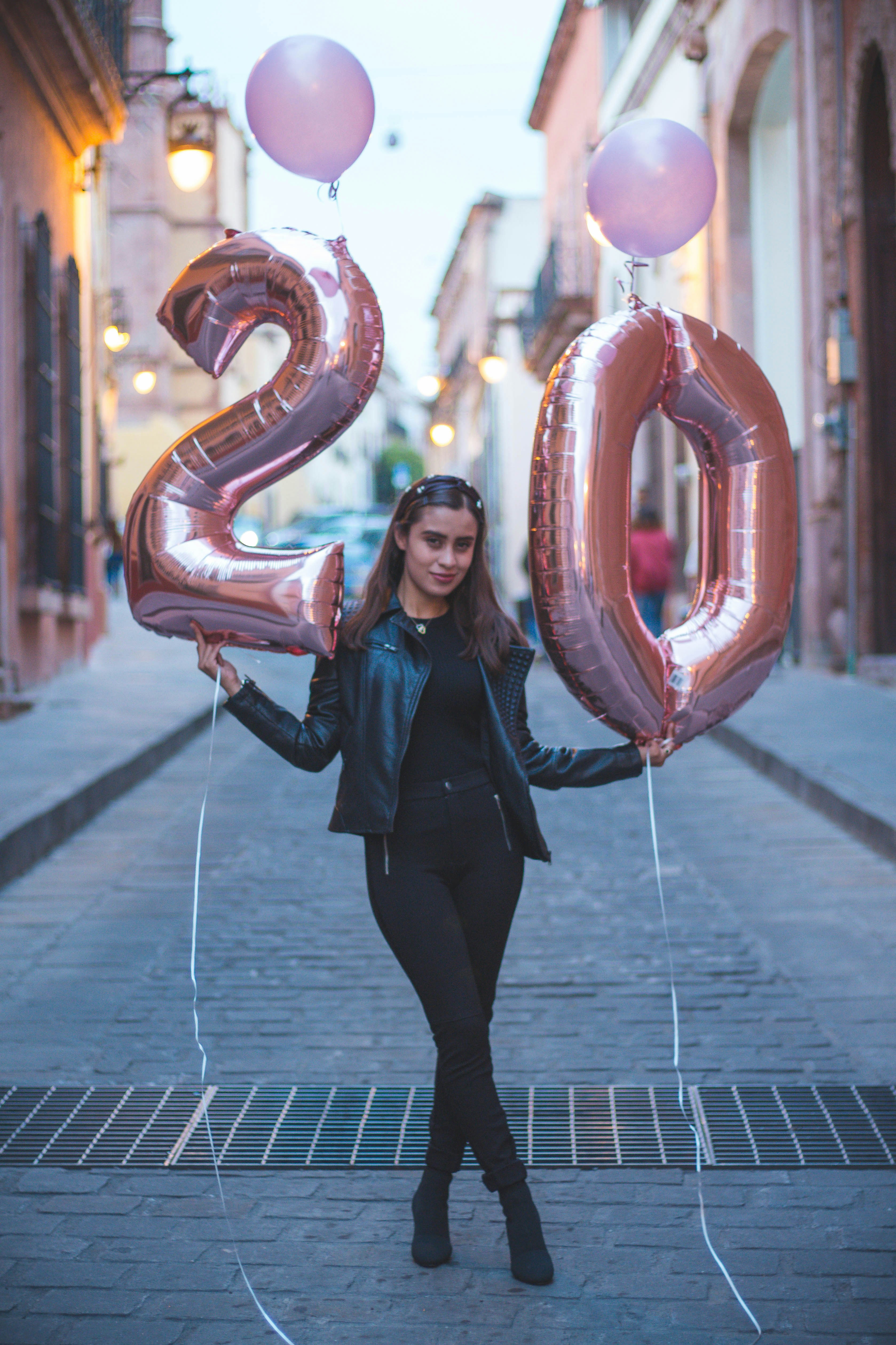 woman in black leather jacket holding heart shaped balloons