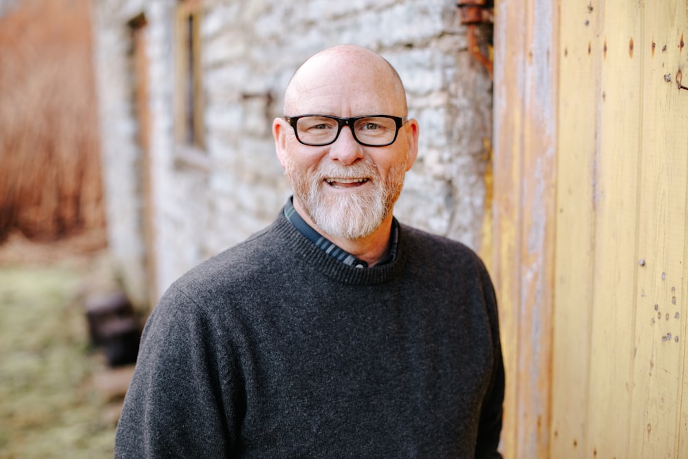 man in black crew neck sweater wearing black framed eyeglasses