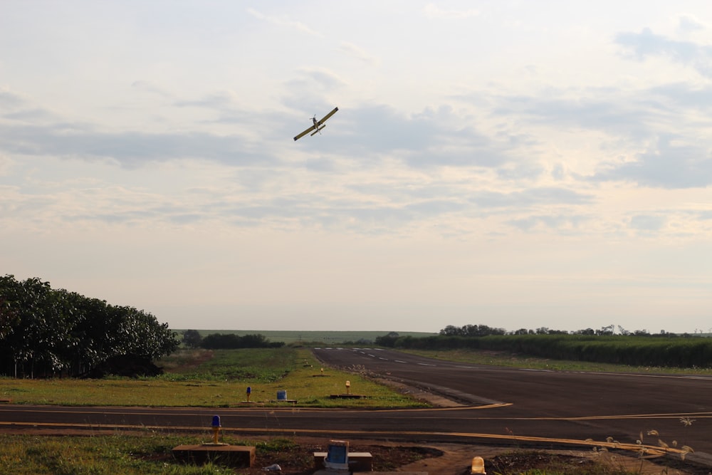 black and white airplane flying over green grass field during daytime