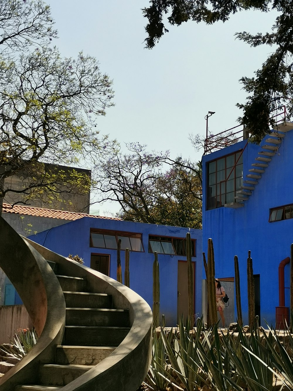 blue and white concrete building near green trees during daytime