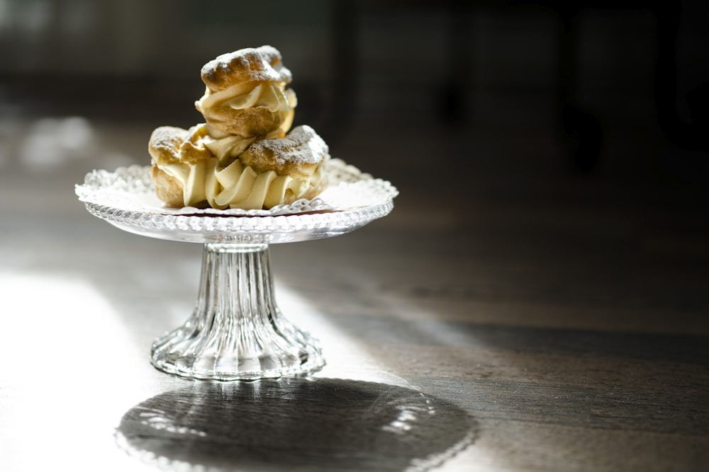 white and brown cupcake on clear glass cake stand