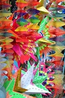 A vibrant baby welcome decoration featuring blue paper cutouts shaped like stars and baby items