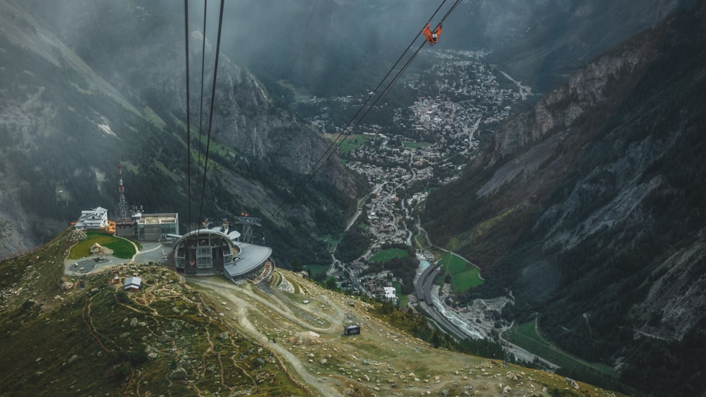 cable cars over green and gray mountains during daytime