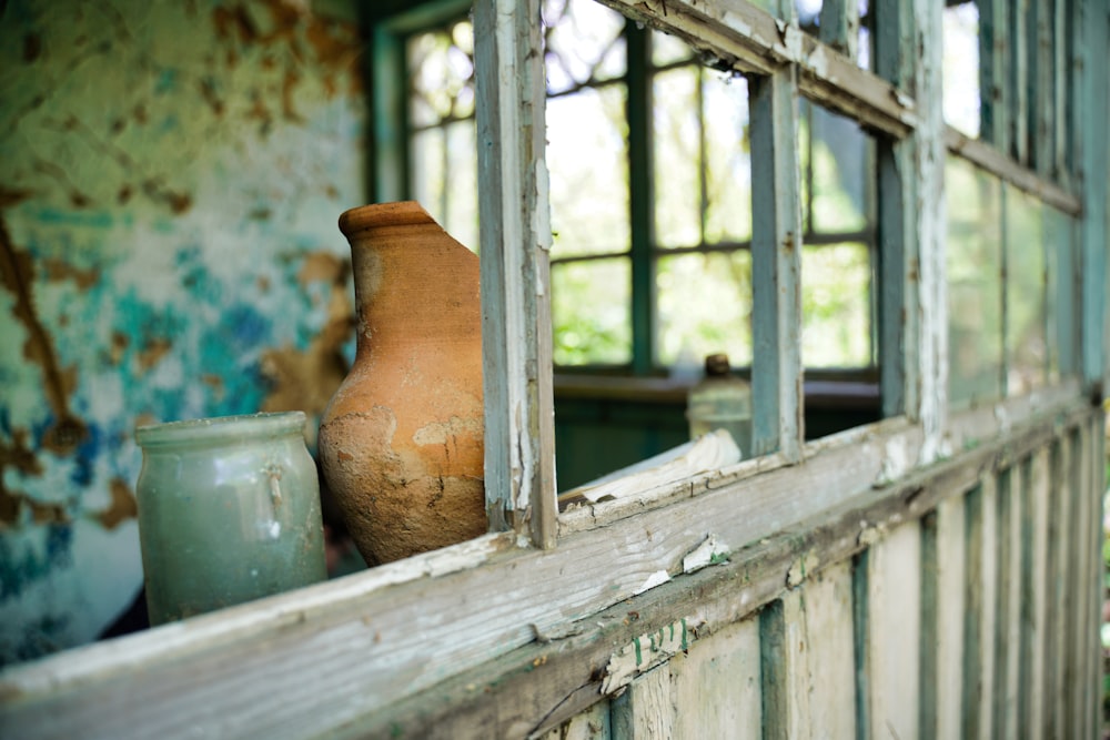 brown clay pot on white wooden window