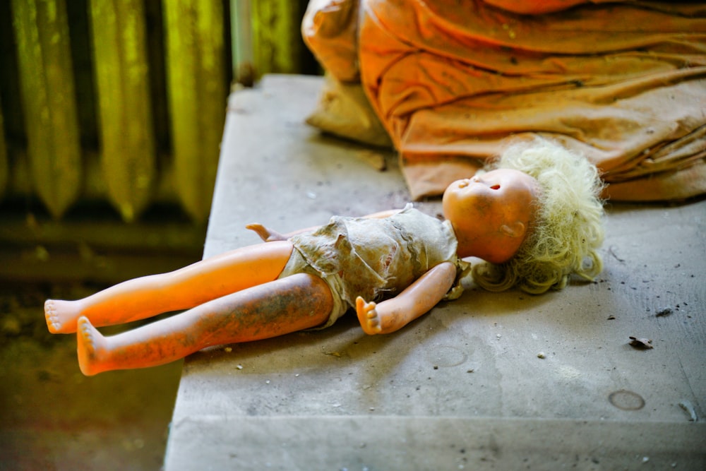 Frau in orangefarbenem Kleid auf Betonboden liegend